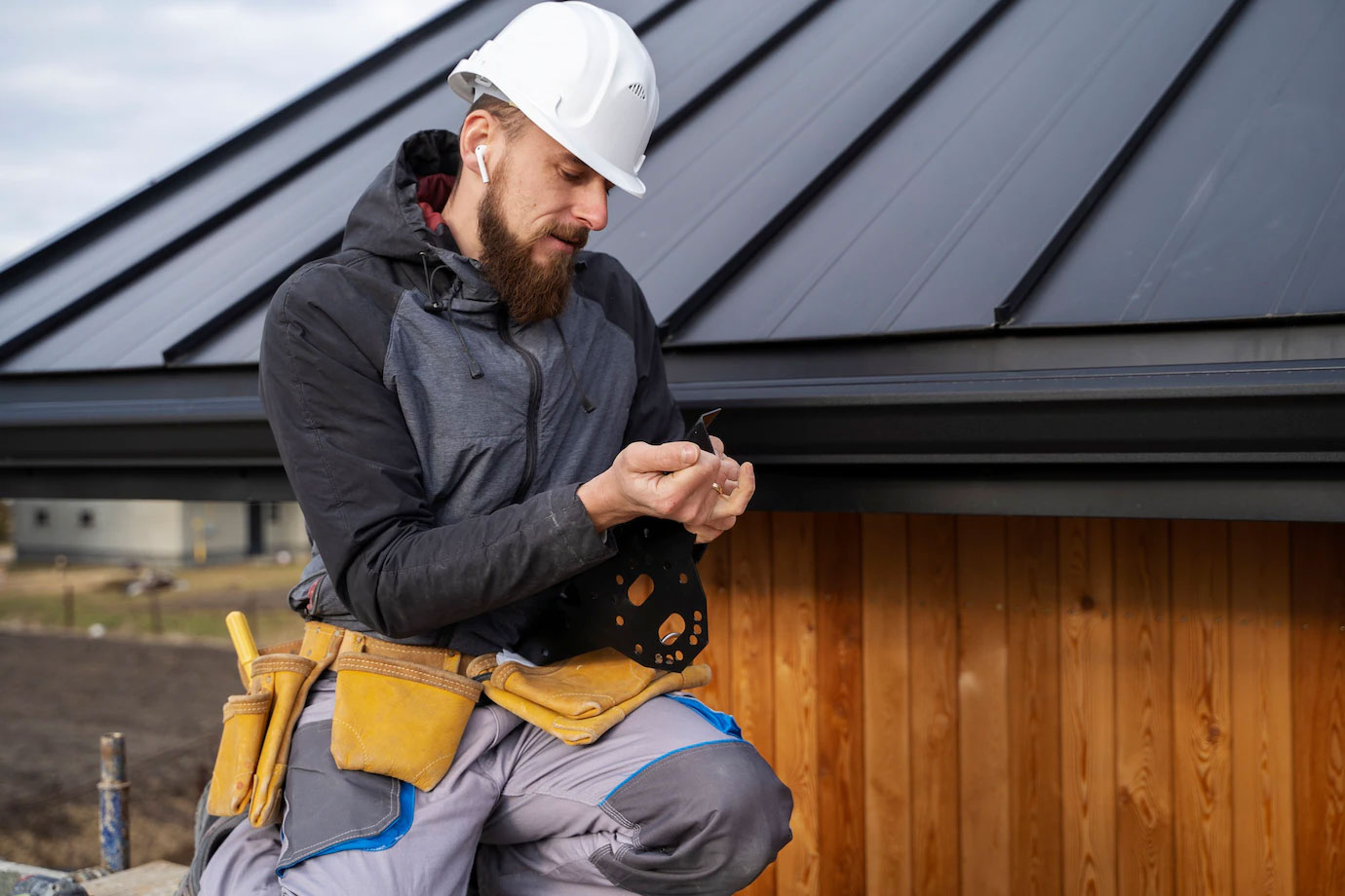 A construction worker in a hard hat holds a tool on his shoulder, symbolizing Titan Exteriors.